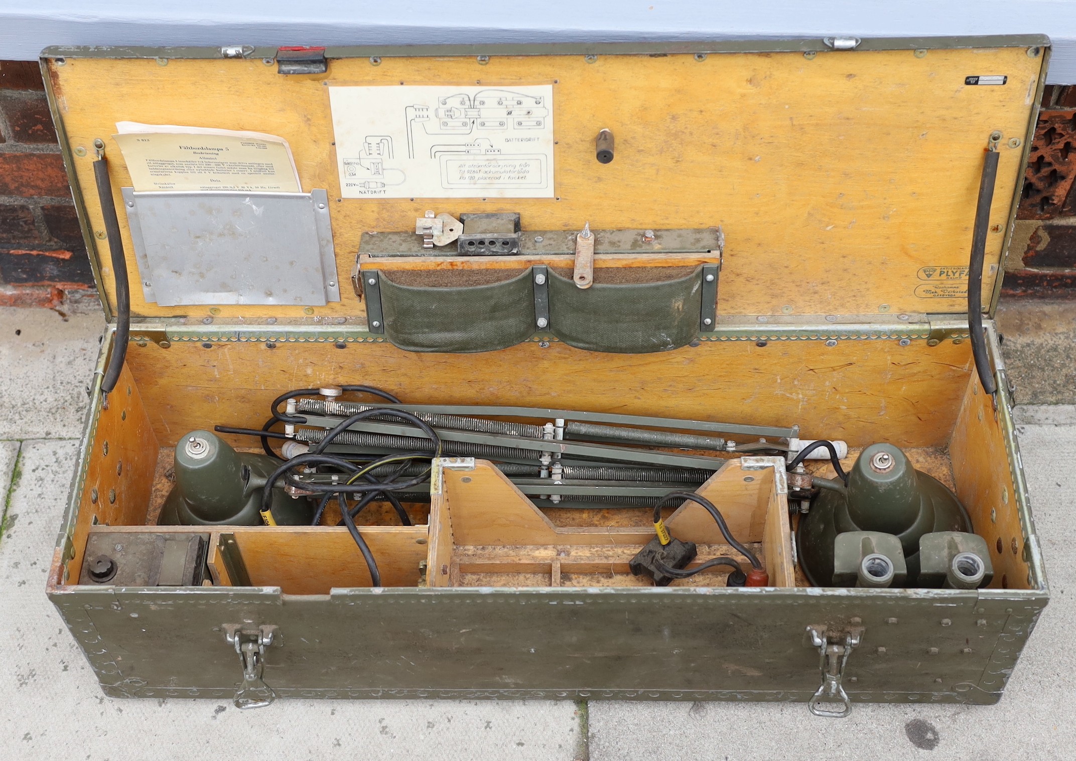 A pair of Swedish Army Carlson Varberg anglepoise lamps with accessories and original instructions dated 1963, in original trunk marked ‘Faltbordslampa 5’, height of lamp to bend 65cm. width of case 83cm